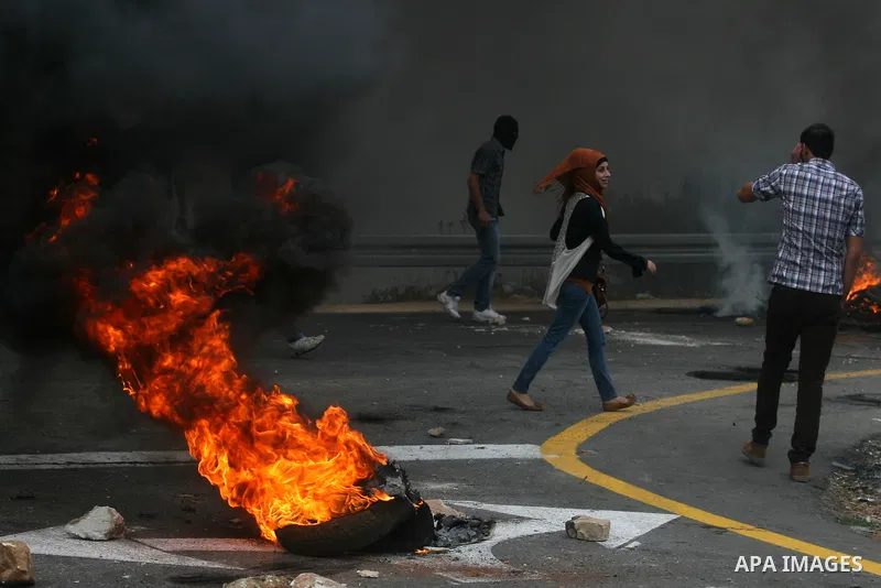 Palestinian youths close streets in Ramallah by burning tires during a protest against the high cost of living on September 10, 2012. Cities across the West Bank ground to a halt as transport unions called a mass general...