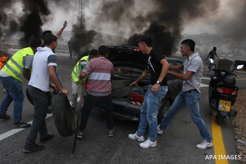 Palestinian youths close streets in Ramallah by burning tires during a protest against the high cost of living on September 10, 2012. Cities across the West Bank ground to a halt as transport unions called a mass general...