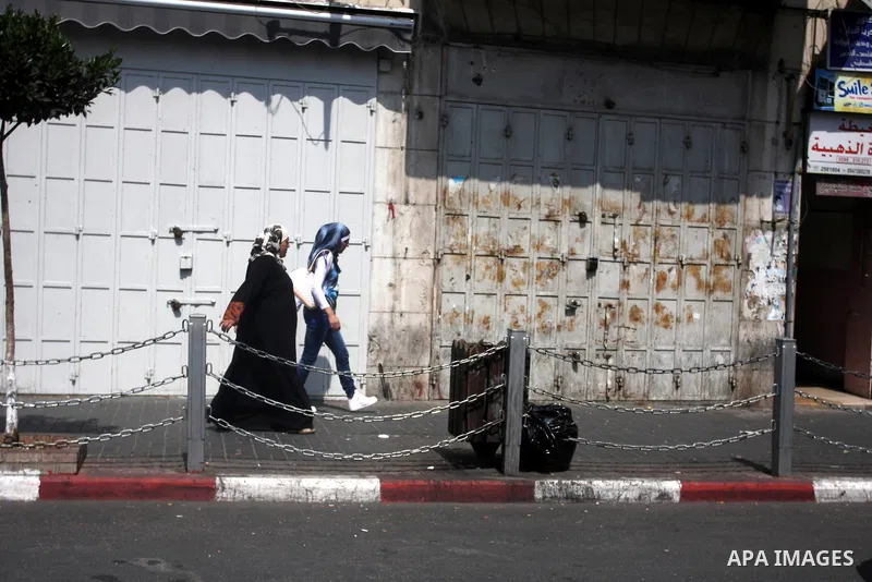 Palestinian Girls walks past closed shops, as Palestinians observe a general strike in protest against the high cost of living in the West Bank city of Ramallah, Sept. 10, 2012. Palestinian demonstrators fed up with high...