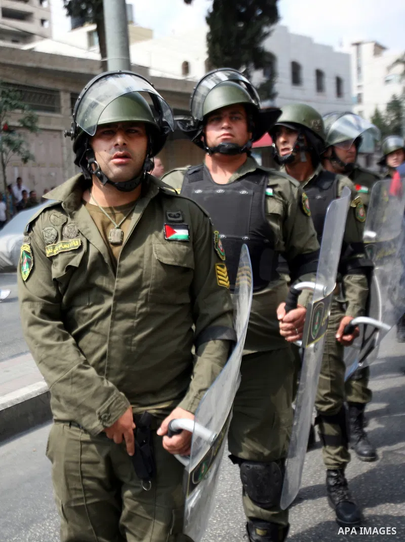 Palestinian police raise their shields to protect from stones thrown by protesters outside the municipality in the southern city of Hebron on September 10, 2012 during a demonstration against the high cost of living. Cit...
