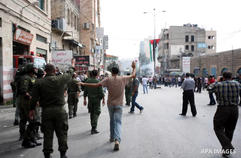 Palestinian police stand guards outside the municipality in the southern city of Hebron on September 10, 2012 during a demonstration against the high cost of living. Cities across the West Bank ground to a halt as transp...