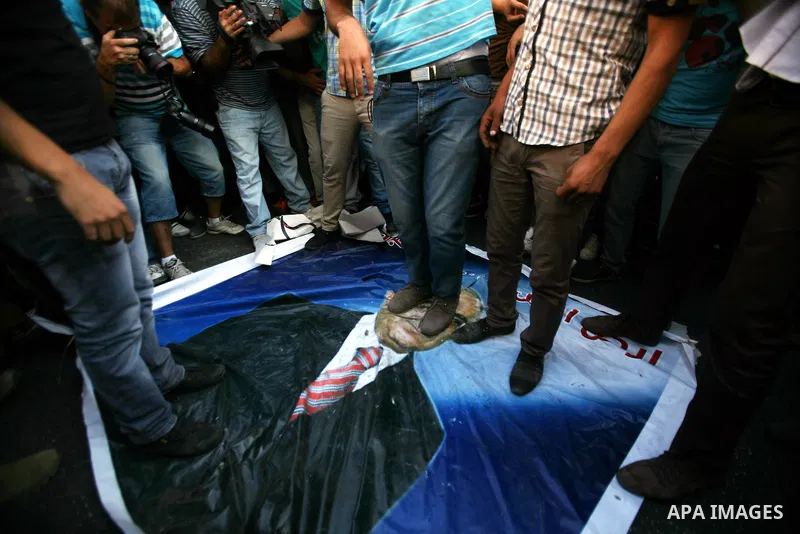 Palestinian protesters stand on a portrait of Prime Minister Salam Fayyad during a demonstration against the high cost of living in the southern West Bank city of Hebron on September 10, 2012. The Palestinian Authority i...