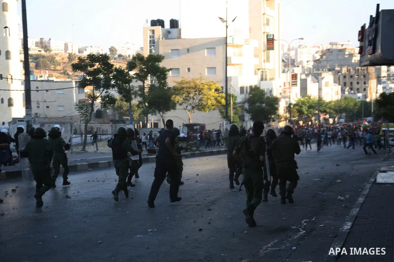 Palestinian security forces disperse crowds outside a police station during clashes at a demonstration against high living costs and the government in the West Bank city of Hebron September 10, 2012. Palestinian youths a...