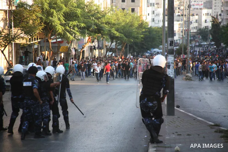 Palestinian security forces disperse crowds outside a police station during clashes at a demonstration against high living costs and the government in the West Bank city of Hebron September 10, 2012. Palestinian youths a...