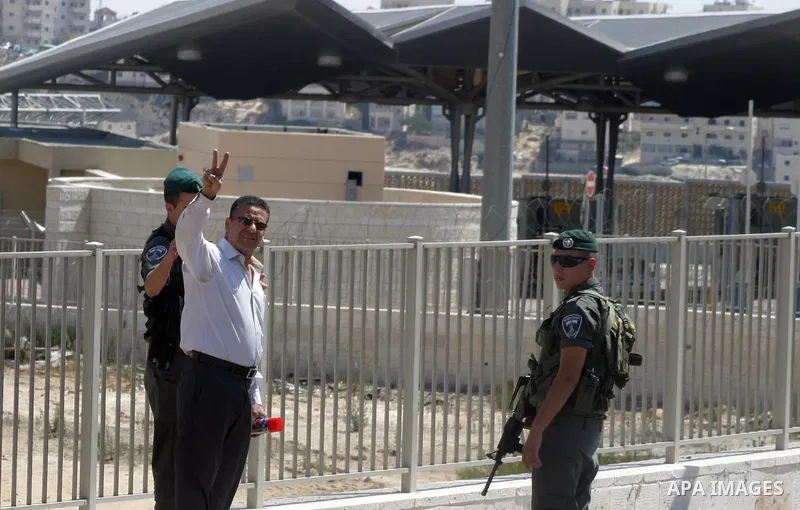 Israeli security forces detain a Palestinian man while an Israeli bulldozer work on the separation barrier in Shu'fat refugee camp in Jerusalem, September 11, 2012. Photo by Mahfouz Abu Turk