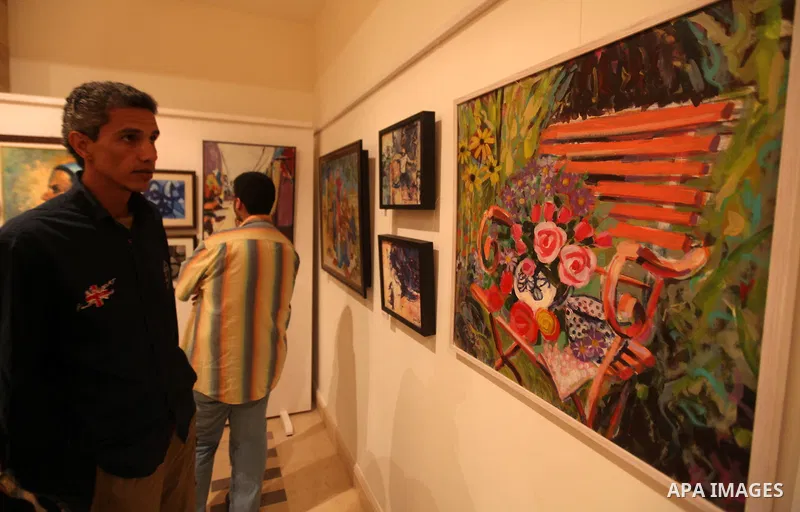 Palestinians attend an exhibition of plastic art at Movenpick Hotel in Gaza City on Sep. 11, 2012. Photo by Majdi Fathi