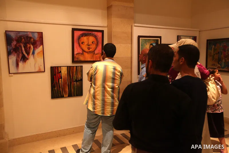 Palestinians attend an exhibition of plastic art at Movenpick Hotel in Gaza City on Sep. 11, 2012. Photo by Majdi Fathi
