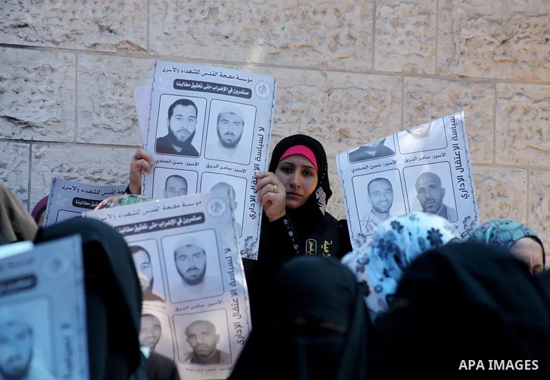 Palestinian women hold a placard depicting jailed relatives during a protest in Gaza City calling for the release of Palestinian prisoners from Israeli jails September 12 2012. Photo by Ashraf Amra