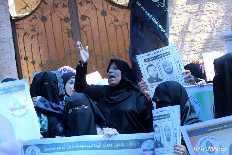 Palestinian women hold a placard depicting jailed relatives during a protest in Gaza City calling for the release of Palestinian prisoners from Israeli jails September 12 2012. Photo by Ashraf Amra