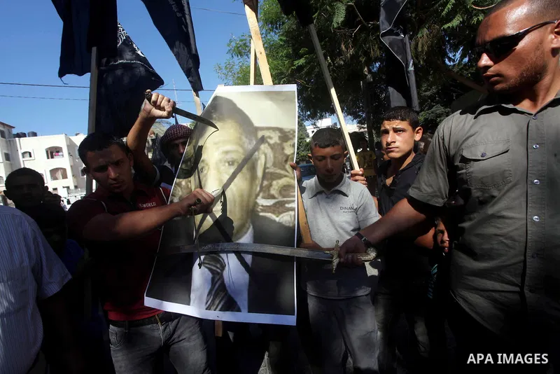 Palestinians point swords on the portrait of the director of a movie that is allegedly offensive to Muslim Prophet Mohammad, during a protest in front of the United Nations headquarters in Gaza city, Sept 12, 2012. Photo...