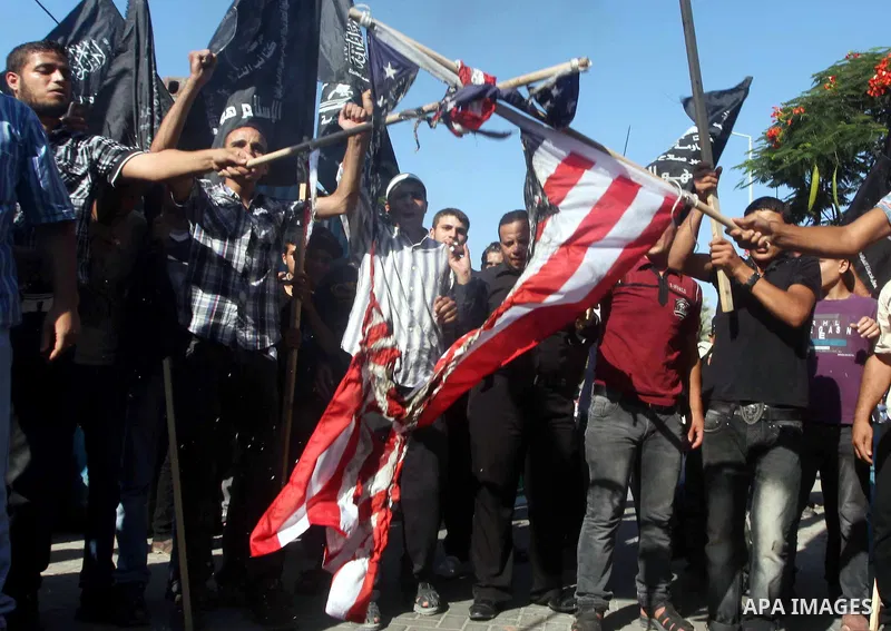 Palestinians burn the U.S. flag during a protest in front of the United Nations headquarters in Gaza city against the showing of a movie that is allegedly offensive to Muslim Prophet Mohammad, Sept 12, 2012. Photo by Ash...