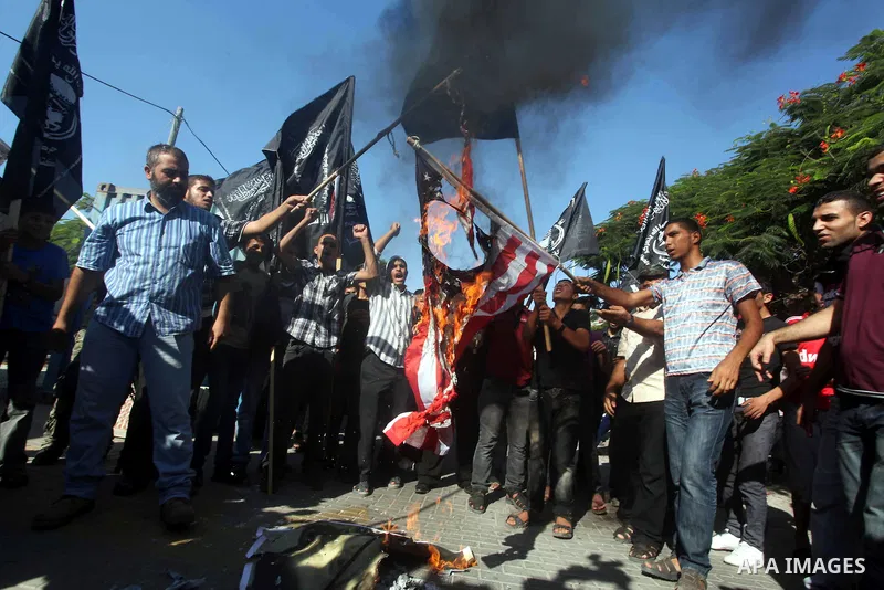 Palestinians burn the U.S. flag during a protest in front of the United Nations headquarters in Gaza city against the showing of a movie that is allegedly offensive to Muslim Prophet Mohammad, Sept 12, 2012. Photo by Ash...