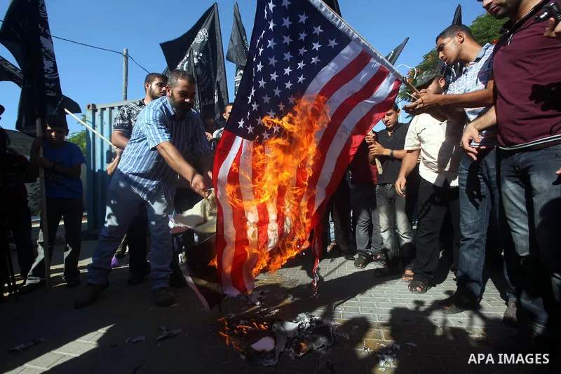 Palestinians burn the U.S. flag during a protest in front of the United Nations headquarters in Gaza city against the showing of a movie that is allegedly offensive to Muslim Prophet Mohammad, Sept 12, 2012. Photo by Ash...