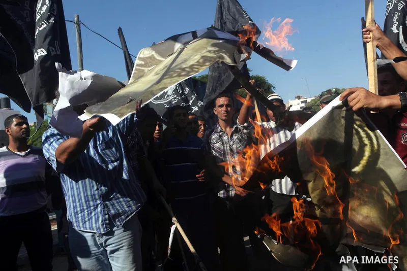 Palestinian burn a portrait of the director of a movie that is allegedly offensive to Muslim Prophet Mohammad, during a protest in front of the United Nations headquarters in Gaza city, Sept 12, 2012. Photo by Ashraf Amr...