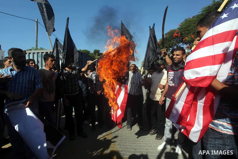 Palestinians burn the U.S. flag during a protest in front of the United Nations headquarters in Gaza city against the showing of a movie that is allegedly offensive to Muslim Prophet Mohammad, Sept 12, 2012. Photo by Ash...