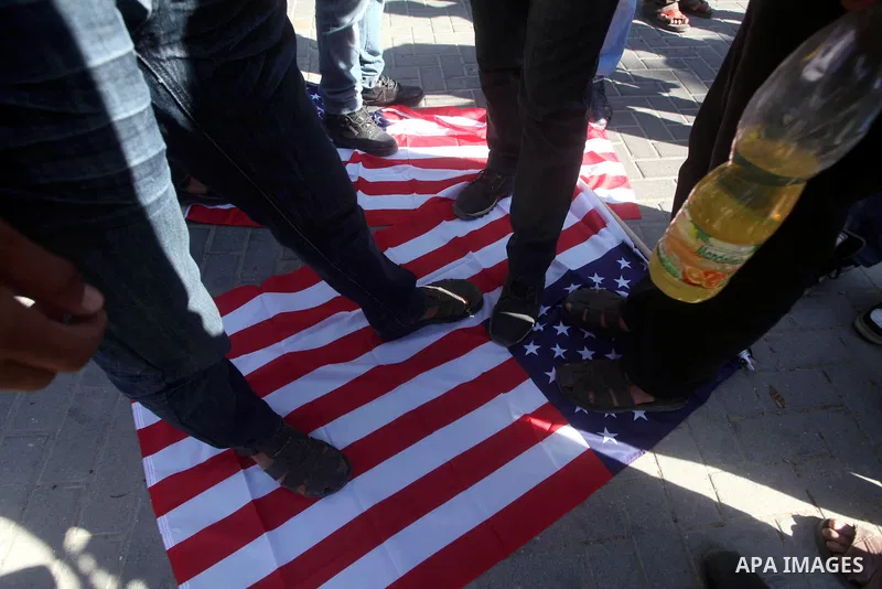 Palestinians stand on the U.S. flag during a protest in front of the United Nations headquarters in Gaza city against the showing of a movie that is allegedly offensive to Muslim Prophet Mohammad, Sept 12, 2012. Photo by...