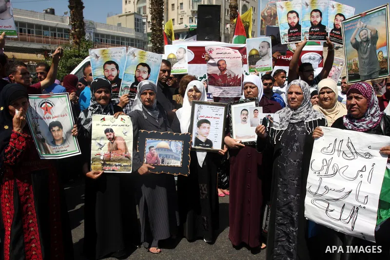 Palestinians hold portraits of their relatives held in Israeli jails during a protest calling for their release, in the West Bank city of Ramallah, Sept. 13, 2012. Photo by Issam Rimawi