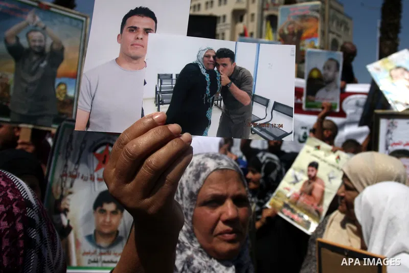 Palestinians hold portraits of their relatives held in Israeli jails during a protest calling for their release, in the West Bank city of Ramallah, Sept. 13, 2012. Photo by Issam Rimawi