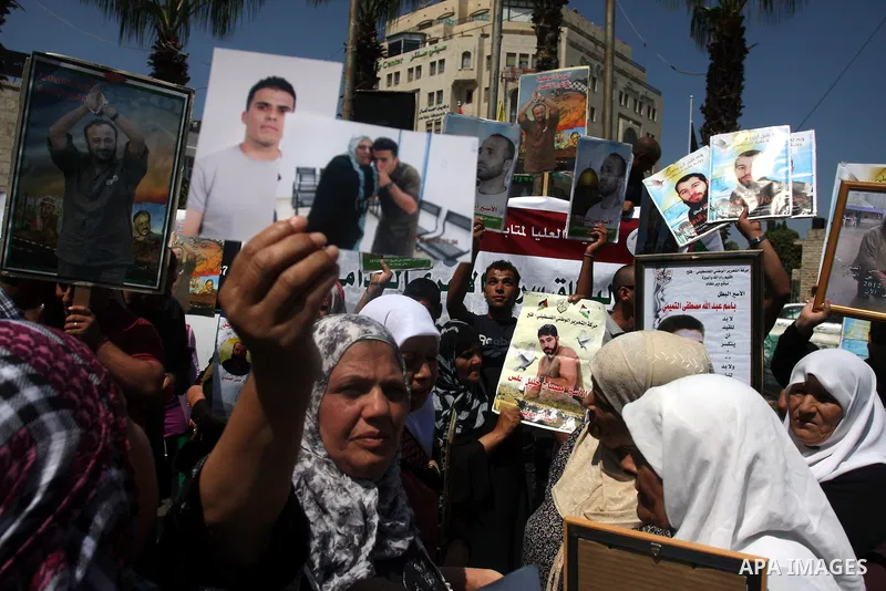 Palestinians hold portraits of their relatives held in Israeli jails during a protest calling for their release, in the West Bank city of Ramallah, Sept. 13, 2012. Photo by Issam Rimawi