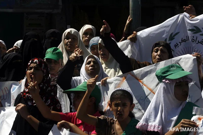 Palestinians hold placards as they shout anti-U.S. slogans during a demonstration against the controversial film 'Innocence of Muslims' in Rafah southern Gaza strip, on September 14, 2012. The controversial low budget fi...