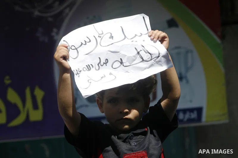A Palestinian child holds a placard during a demonstration against the controversial film 'Innocence of Muslims' in Rafah southern Gaza strip, on September 14, 2012. The controversial low budget film reportedly made by a...
