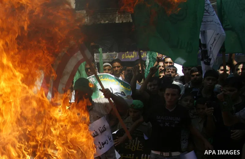 Palestinians burn the U.S. flag during a demonstration against the controversial film 'Innocence of Muslims' in Rafah southern Gaza strip, on September 14, 2012. The controversial low budget film reportedly made by an Is...
