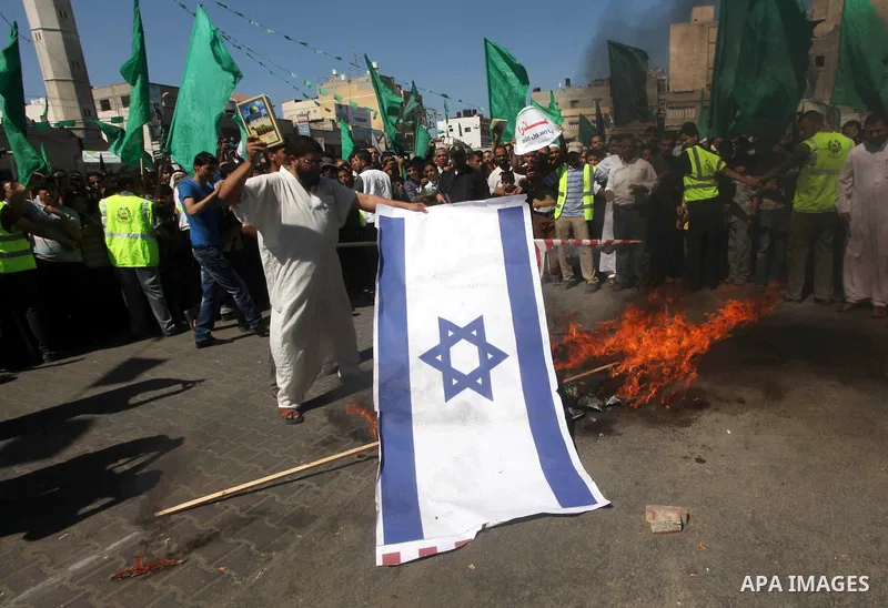 Palestinians burn the Israeli and the U.S. flags during a demonstration against the controversial film 'Innocence of Muslims' in Khan Younis southern Gaza strip, on September 14, 2012. The controversial low budget film r...
