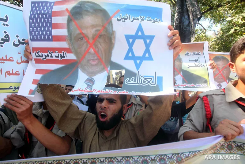 Palestinians hold placards as they shout anti-U.S. slogans during a demonstration against the controversial film 'Innocence of Muslims' in Khan Younis southern Gaza strip, on September 14, 2012. The controversial low bud...