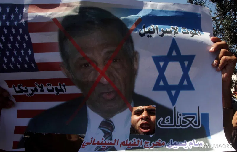 Palestinians hold placards as they shout anti-U.S. slogans during a demonstration against the controversial film 'Innocence of Muslims' in Khan Younis southern Gaza strip, on September 14, 2012. The controversial low bud...