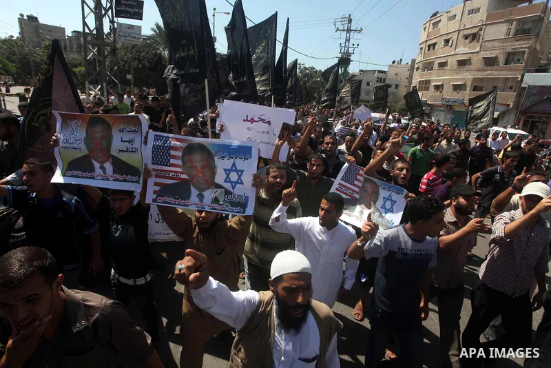 Palestinians hold placards as they shout anti-U.S. slogans during a demonstration against the controversial film 'Innocence of Muslims' in Khan Younis southern Gaza strip, on September 14, 2012. The controversial low bud...