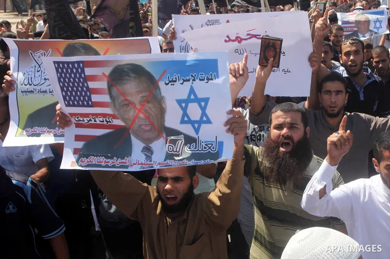 Palestinians hold placards as they shout anti-U.S. slogans during a demonstration against the controversial film 'Innocence of Muslims' in Khan Younis southern Gaza strip, on September 14, 2012. The controversial low bud...