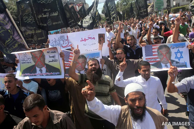 Palestinians hold placards as they shout anti-U.S. slogans during a demonstration against the controversial film 'Innocence of Muslims' in Khan Younis southern Gaza strip, on September 14, 2012. The controversial low bud...