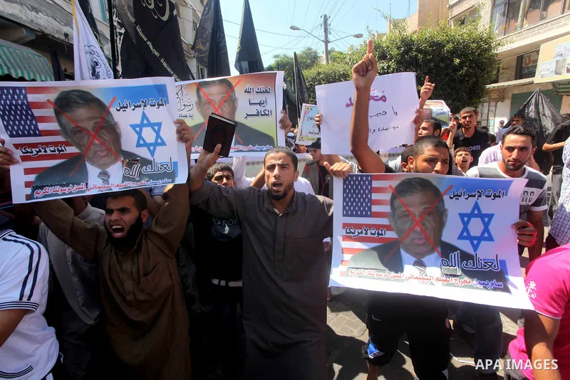 Palestinians hold placards as they shout anti-U.S. slogans during a demonstration against the controversial film 'Innocence of Muslims' in Khan Younis southern Gaza strip, on September 14, 2012. The controversial low bud...