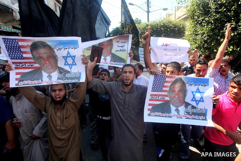 Palestinians hold placards as they shout anti-U.S. slogans during a demonstration against the controversial film 'Innocence of Muslims' in Khan Younis southern Gaza strip, on September 14, 2012. The controversial low bud...