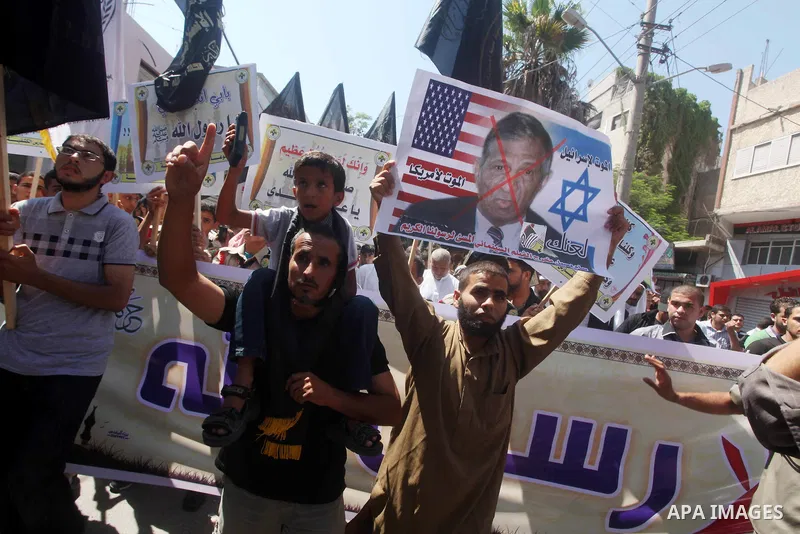 Palestinians hold placards as they shout anti-U.S. slogans during a demonstration against the controversial film 'Innocence of Muslims' in Khan Younis southern Gaza strip, on September 14, 2012. The controversial low bud...