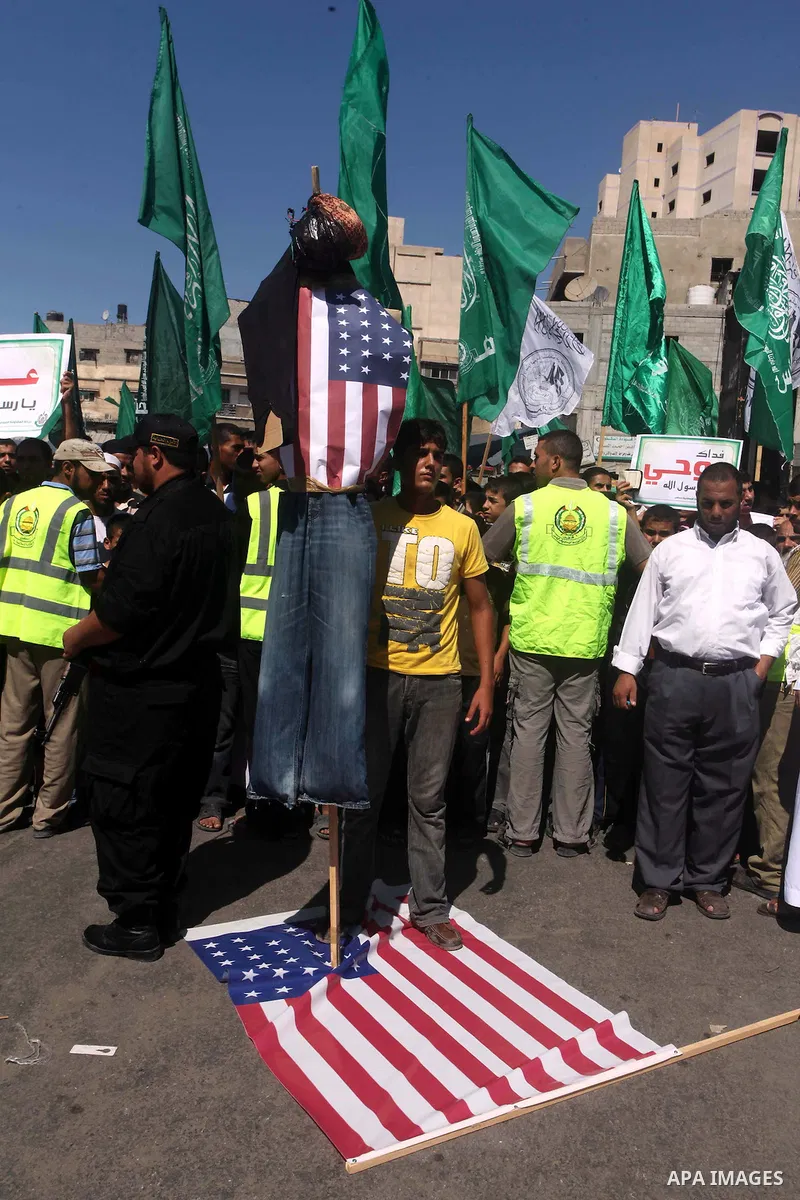 Palestinians walk on the U.S. flag during a demonstration against the controversial film 'Innocence of Muslims' in Khan Younis southern Gaza strip, on September 14, 2012. The controversial low budget film reportedly made...