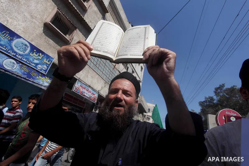 A Palestinian man holds the holy Qur'an during a demonstration against the controversial film 'Innocence of Muslims' in Khan Younis southern Gaza strip, on September 14, 2012. The controversial low budget film reportedly...