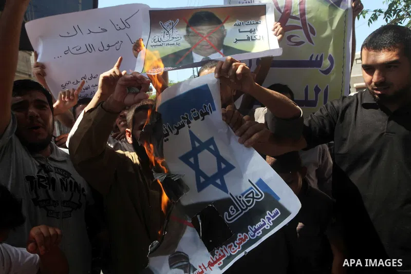 Palestinians burn a portrait of the director of controversial film 'Innocence of Muslims' during a demonstration in Khan Younis southern Gaza strip, on September 14, 2012. The controversial low budget film reportedly mad...