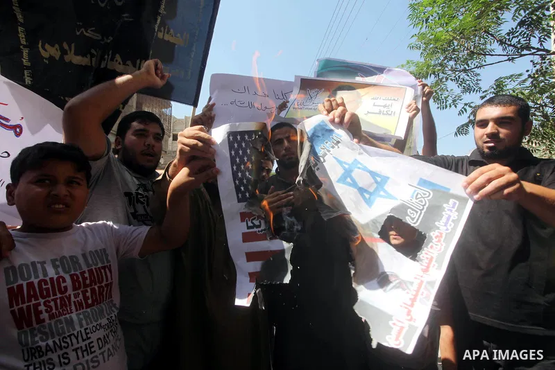 Palestinians burn a portrait of the director of controversial film 'Innocence of Muslims' during a demonstration in Khan Younis southern Gaza strip, on September 14, 2012. The controversial low budget film reportedly mad...
