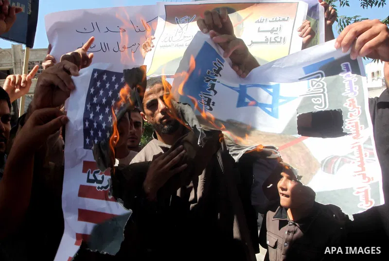Palestinians burn a portrait of the director of controversial film 'Innocence of Muslims' during a demonstration in Khan Younis southern Gaza strip, on September 14, 2012. The controversial low budget film reportedly mad...