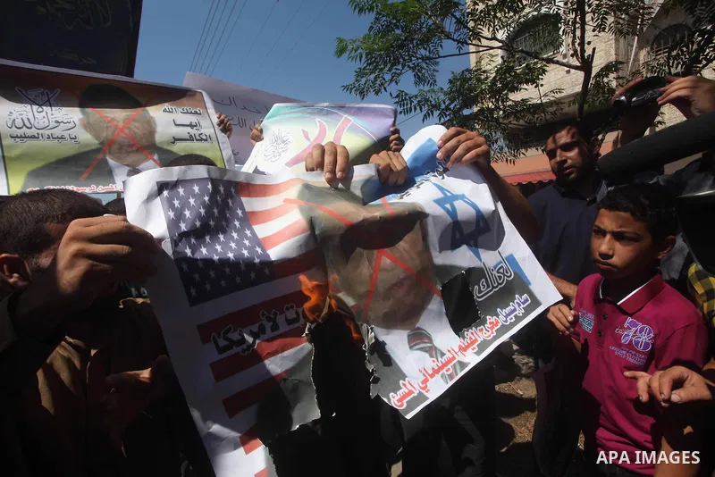 Palestinians burn a portrait of the director of controversial film 'Innocence of Muslims' during a demonstration in Khan Younis southern Gaza strip, on September 14, 2012. The controversial low budget film reportedly mad...