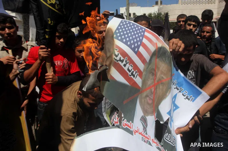 Palestinians burn a portrait of the director of controversial film 'Innocence of Muslims' during a demonstration in Khan Younis southern Gaza strip, on September 14, 2012. The controversial low budget film reportedly mad...