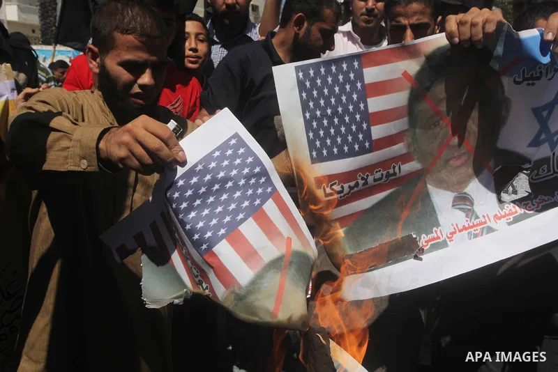 Palestinians burn a portrait of the director of controversial film 'Innocence of Muslims' during a demonstration in Khan Younis southern Gaza strip, on September 14, 2012. The controversial low budget film reportedly mad...