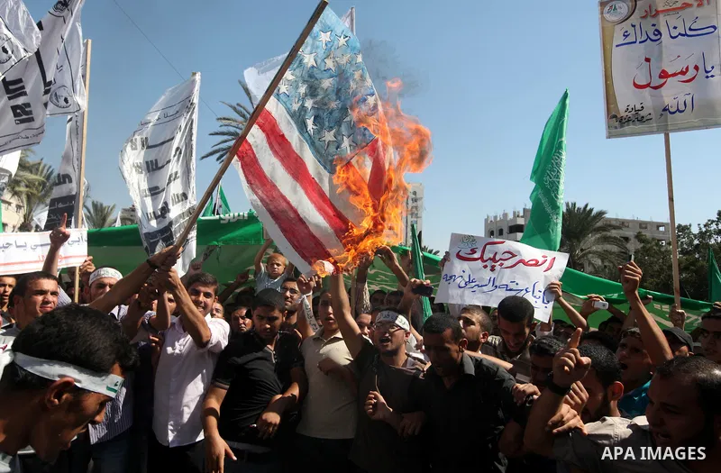 Palestinians burn the U.S. flags during a demonstration against the controversial film 'Innocence of Muslims' in Gaza city, on September 14, 2012. The controversial low budget film reportedly made by an Israeli-American...