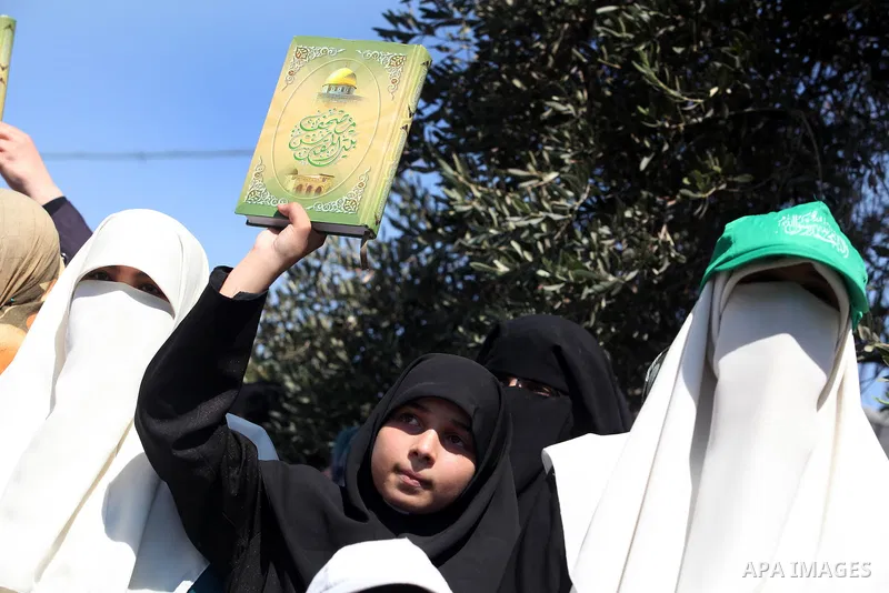 A Palestinian girl holds holy Qur'an during a demonstration against the controversial film 'Innocence of Muslims' in Gaza City, on September 14, 2012. The controversial low budget film reportedly made by an Israeli-Ameri...
