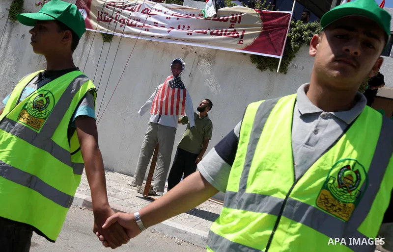 A Palestinian man stands near the U.S. flag toy during a demonstration against the controversial film 'Innocence of Muslims' in Gaza city, on September 14, 2012. The controversial low budget film reportedly made by an Is...