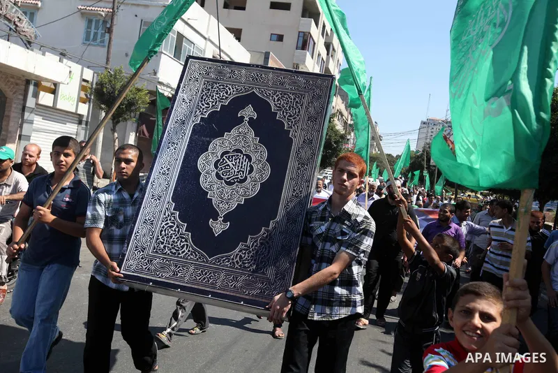A Palestinian man stands near the U.S. flag toy during a demonstration against the controversial film 'Innocence of Muslims' in Gaza city, on September 14, 2012. The controversial low budget film reportedly made by an Is...