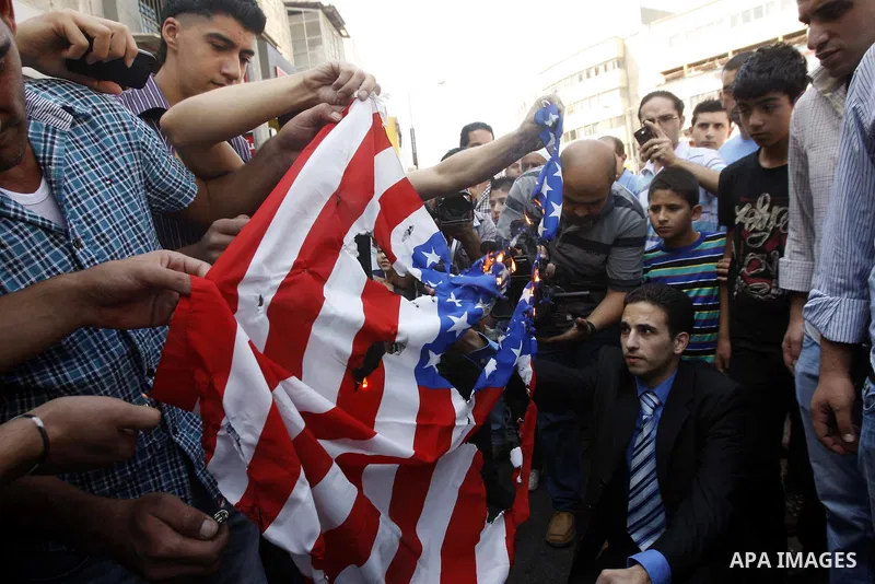 Palestinians burn the U.S. flag during a demonstration against the controversial film 'Innocence of Muslims' in the West Bank city of Nablus, on September 14, 2012. The controversial low budget film reportedly made by an...