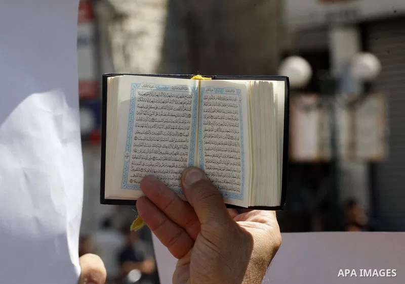 A Palestinian holds up a copy of the Quran during a demonstration against the controversial film 'Innocence of Muslims' in the West Bank city of Nablus, on September 14, 2012. The controversial low budget film reportedly...