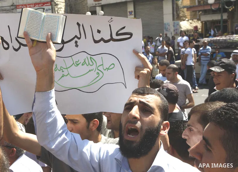 A Palestinian holds up a copy of the Quran during a demonstration against the controversial film 'Innocence of Muslims' in the West Bank city of Nablus, on September 14, 2012. The controversial low budget film reportedly...
